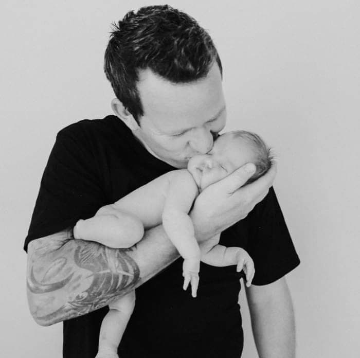 Nick holding his newborn, a quiet family moment